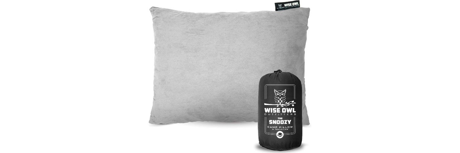 A gray travel pillow by Wise Owl Outfitters, called "The Snoozy Camp Pillow," shown with its black drawstring carry bag featuring the Wise Owl Outfitters logo.